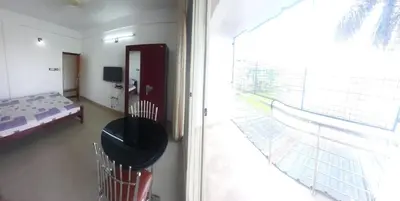a bedroom with a bed and a large window at Green Garden Apartments in Kodungallūr