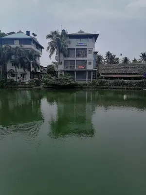 a large building next to a body of water at Green Garden Apartments in Kodungallūr