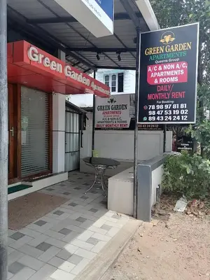 a green garden restaurant with a table and a sign at Green Garden Apartments in Kodungallūr