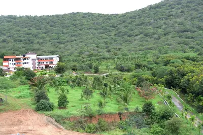 a village on a hill with trees and buildings at NIRVANA HOLISTIC LIVING in Varagampadi
