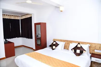 a bedroom with a bed with white sheets and pillows at NIRVANA HOLISTIC LIVING in Varagampadi