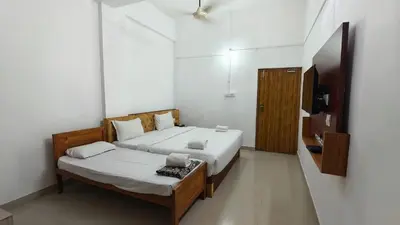 a bedroom with a bed and a television in it at NIRVANA HOLISTIC LIVING in Varagampadi