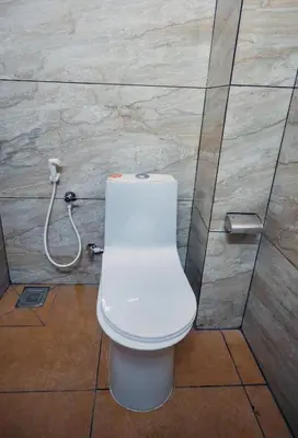 a bathroom with a white toilet in a stall at Chakalakkal Residency in Sultan Bathery