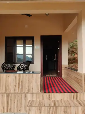 a lobby with two chairs and a red carpet at Forest and River Edge Resort in Kannur