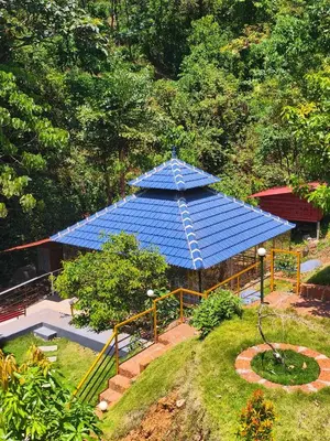 a blue pavilion with a blue roof in a garden at Forest and River Edge Resort in Kannur