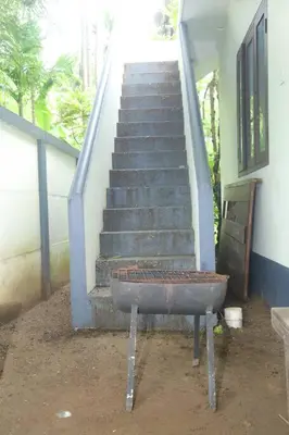 a staircase with a rusty pot in front of a building at Forestay -3 BHK Villa Kochi in Pallipuram