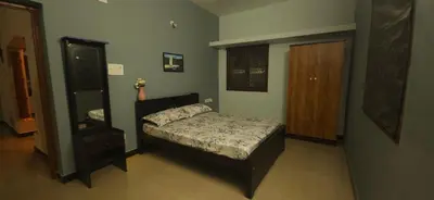 a small bedroom with a bed and a mirror at SHI's Triveni Spacious 2BHK Villa in Pappampatti, Coimbatore in Coimbatore