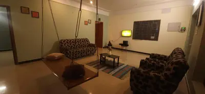 a living room with two chairs and a table at SHI's Triveni Spacious 2BHK Villa in Pappampatti, Coimbatore in Coimbatore