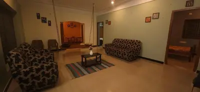 a living room with two chairs and a table at SHI's Triveni Spacious 2BHK Villa in Pappampatti, Coimbatore in Coimbatore