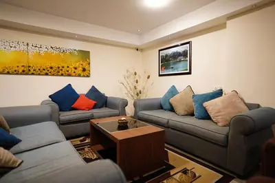 a living room with couches and a coffee table at Emarald Hotel Calicut in Kozhikode