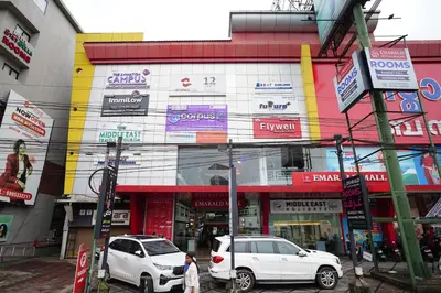 two white cars parked in front of a building at Emarald Hotel Calicut in Kozhikode