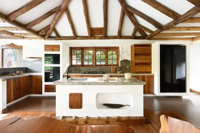 a kitchen with a white island in a room with wooden ceilings at Earthitects Holiday Experiences,Wayanad in Kalpetta