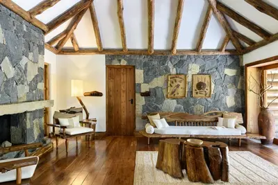 a bedroom with a bed and a stone wall at Earthitects Holiday Experiences,Wayanad in Kalpetta