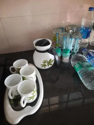 a counter top with cups and other items on it at NEST Mdy in Mananthavady