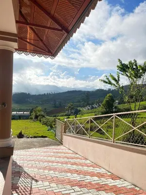 a porch of a house with a view of a field at Mysterious mountain in Ooty