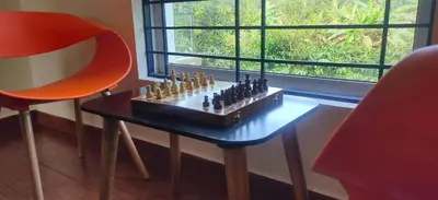 a chess board on a table next to a window at Empra Exotica in Madikeri