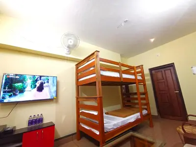 a room with bunk beds and a flat screen tv at Golden Peak Estate Homestay in Wayanad