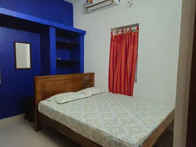 a bedroom with a bed and a red curtain at SHI's Bhairavi Peaceful 2bhk villa - - On the way 2 isha-Adiyogi , Maruthamalai in Coimbatore