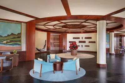a lobby with a round table and blue chairs at Taj Wayanad Resort & Spa, Kerala in Wayanad