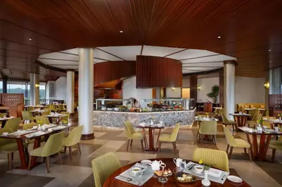 a restaurant with tables and chairs and a bar at Taj Wayanad Resort & Spa, Kerala in Wayanad