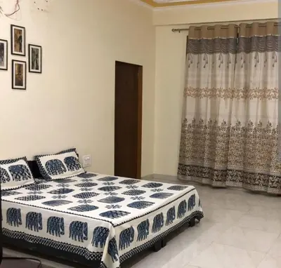 a bedroom with a blue and white bed and a window at KK Residency in Perintalmanna
