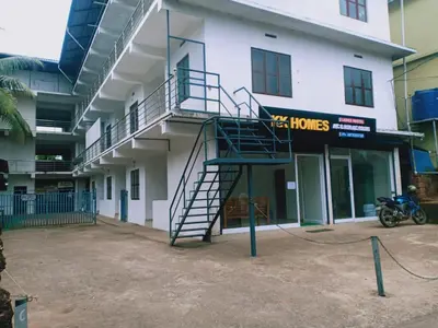 a building with a spiral staircase in front of a building at KK Residency in Perintalmanna