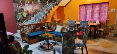 a room with a couch and a table and stairs at JJ's White House in Trichūr