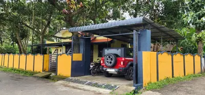 a small house with a red jeep parked under a shed at JJ's Holiday Home in Thanniyam