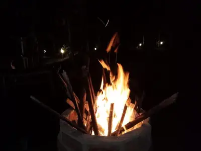 a fire pit at night with flames in it at Cave Valley Wayanad in Ambalavayal