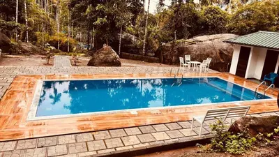 a swimming pool in a yard with a table and chairs at Cave Valley Wayanad in Ambalavayal