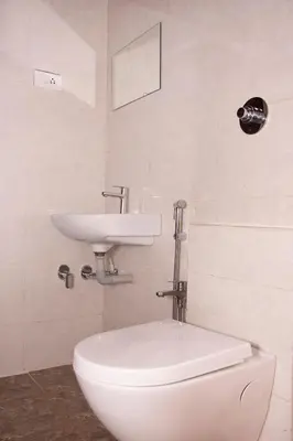 a bathroom with a white toilet and a sink at Deepwoods Stay-Kinathukadavu, Coimbatore in Coimbatore