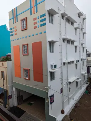 a building with colored squares on the side of it at Lakshmi Paradise Lodge A/C in Pollāchi