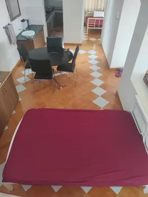 a living room with a red mat on the floor at The Orange Home in Kotagiri