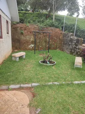 a small park with a basketball hoop and two benches at The Orange Home in Kotagiri