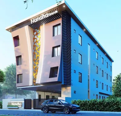 a building with a car parked in front of it at Nandha Grande in Udumalaippettai