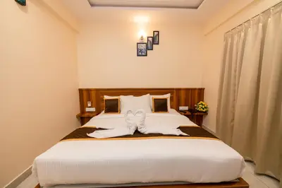 a bedroom with a large bed with white sheets at KK Comforts in Shrīrangapattana