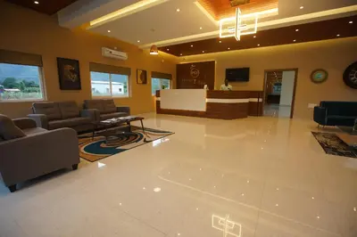 a lobby with a waiting room with chairs and a table at Hotel PSY in Mettuppālaiyam