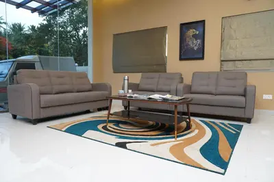a living room with two couches and a coffee table at Hotel PSY in Mettuppālaiyam