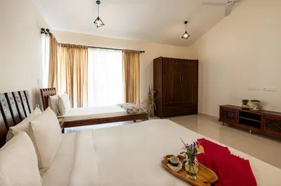 a living room with a large bed and a couch at ama Stays & Trails Arcadia, Coorg in Madikeri