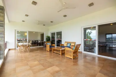 a living room with a table and chairs and a dining room at ama Stays & Trails Arcadia, Coorg in Madikeri