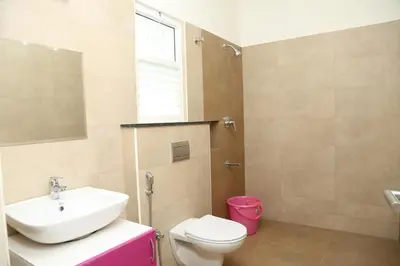 a bathroom with a sink and a toilet and a window at The best villa stay- family friendly in Coimbatore