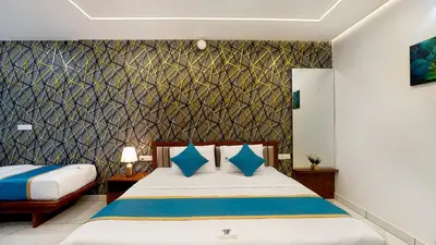 a bedroom with a bed with blue pillows at Royal Tusker Luxury Service Apartments in Mysore