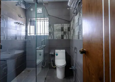 a bathroom with a toilet and a sink at Royal Tusker Luxury Service Apartments in Mysore