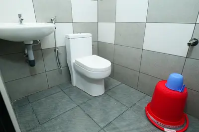 a bathroom with a toilet and a sink at Hillside Hideaway Gudalur in Gūdalūr