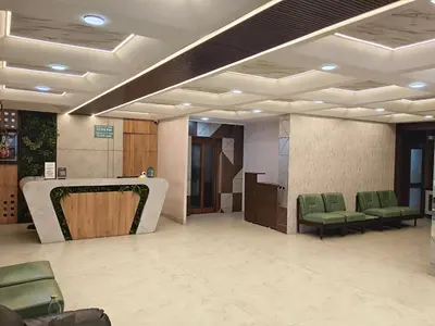 a lobby with a waiting room with green chairs at NavaRATNA Delight in Coimbatore