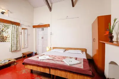 a bedroom with a large bed in a room at DEVASHOLA HOMESTAY in Coonoor
