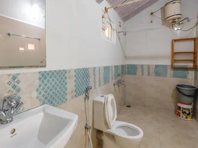 a bathroom with a toilet and a sink at DEVASHOLA HOMESTAY in Coonoor