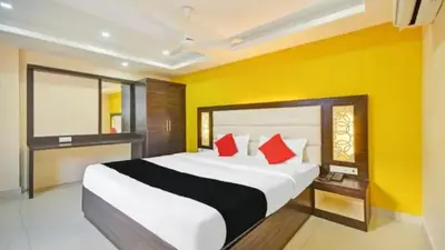 a bedroom with a large bed with red pillows at PPH Living TriColours Hotel Gandhipuram in Coimbatore