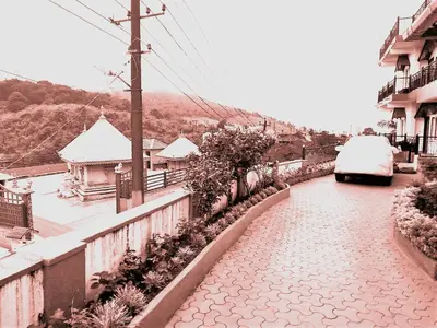 a snow covered street with a car parked on the road at New Hill Valley Family Homestay-WiFi-View in Madikeri