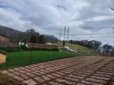 a dirt road with a fence in front of a field at Forest Gate only family in Ooty